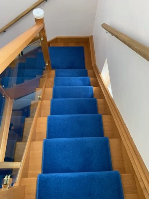 Staircase with clean blue carpet, serviced by Spotclean Ltd in London.